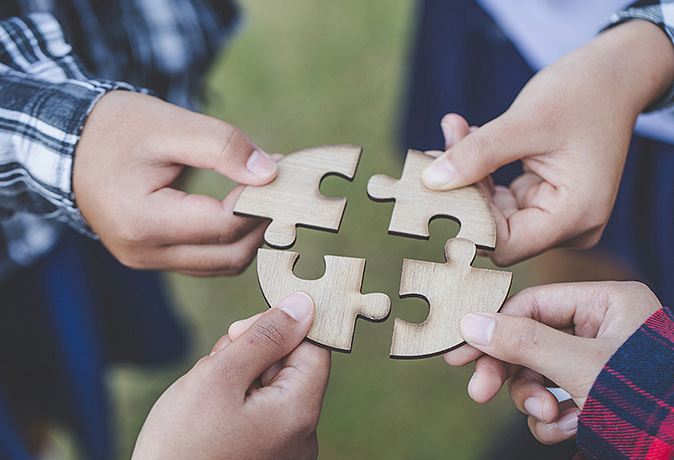 people holding puzzle pieces